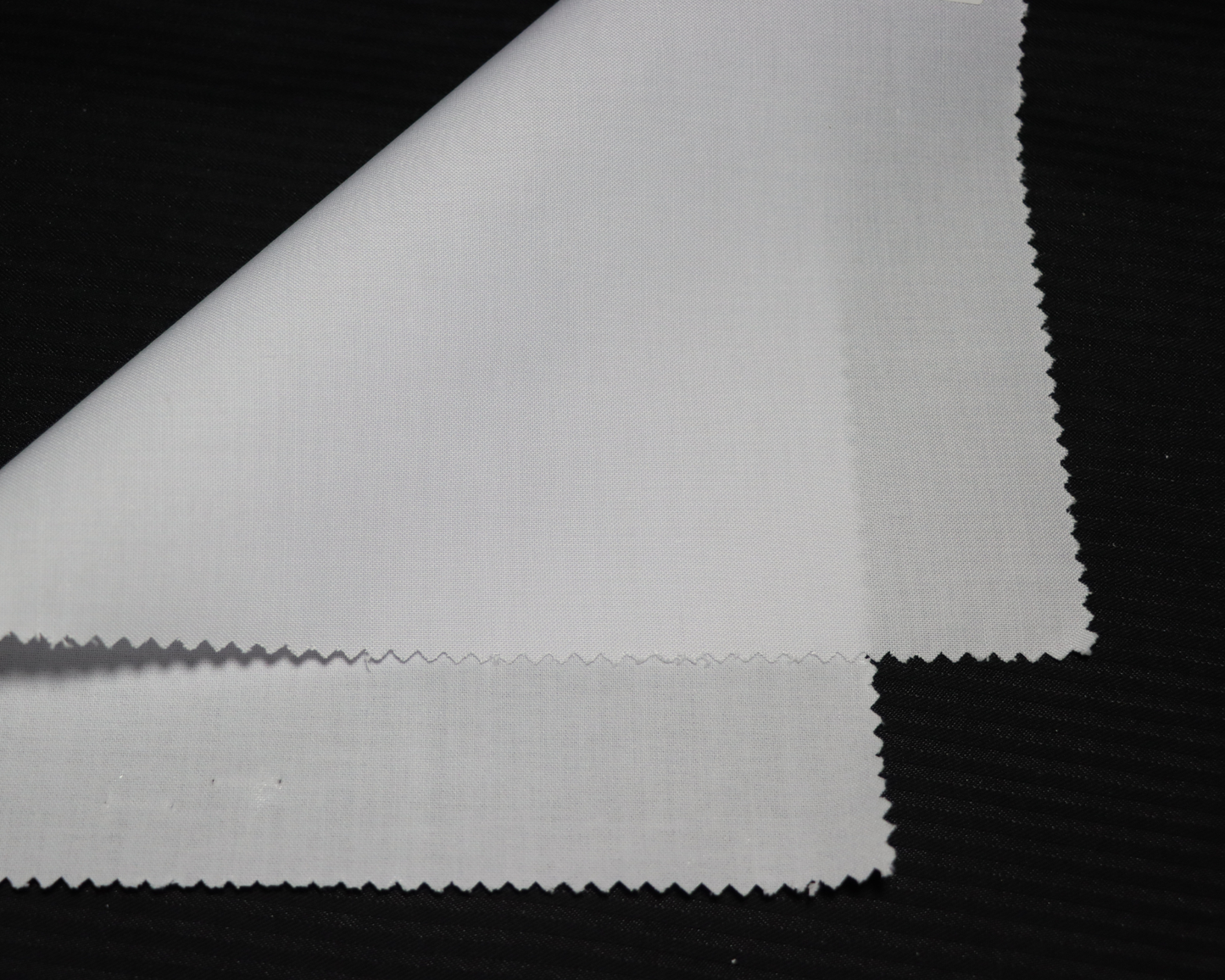 Close-up of white interlining fabric  on a black background