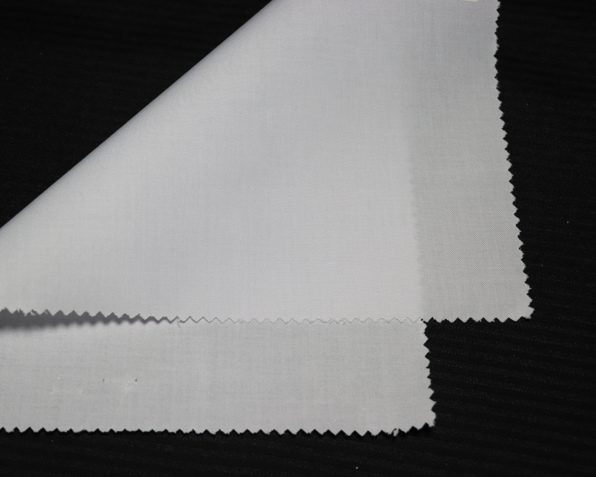 Close-up of white interlining fabric  on a black background