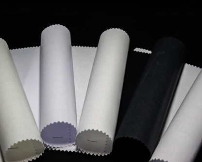 Rolls of IF2777 fabric interlining in various colors on a black background