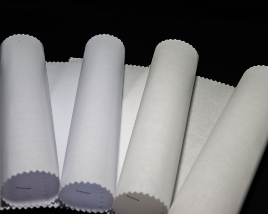 fusible interlining fabric rolls of shades of white on a black background