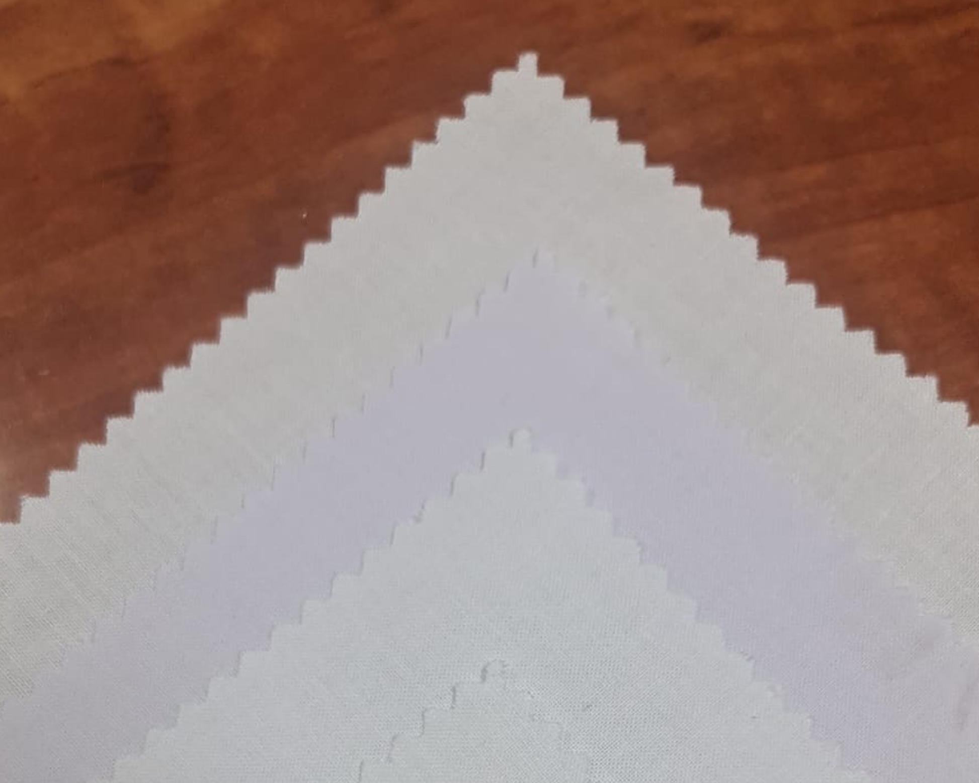 Fabric swatch pyramid with white placket interlining on wooden background