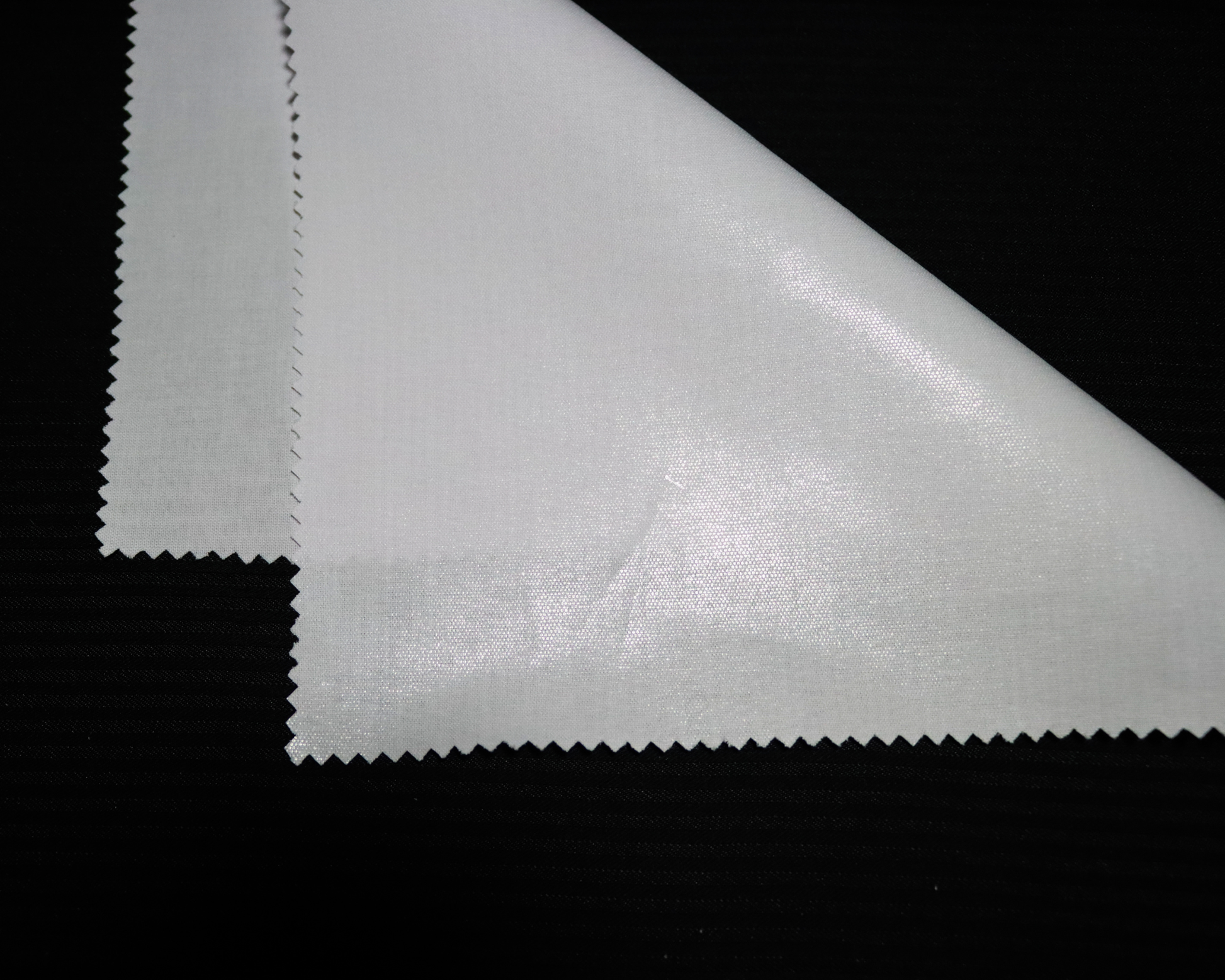 Close-up of an IF3903 white  interlining material sample on a black background