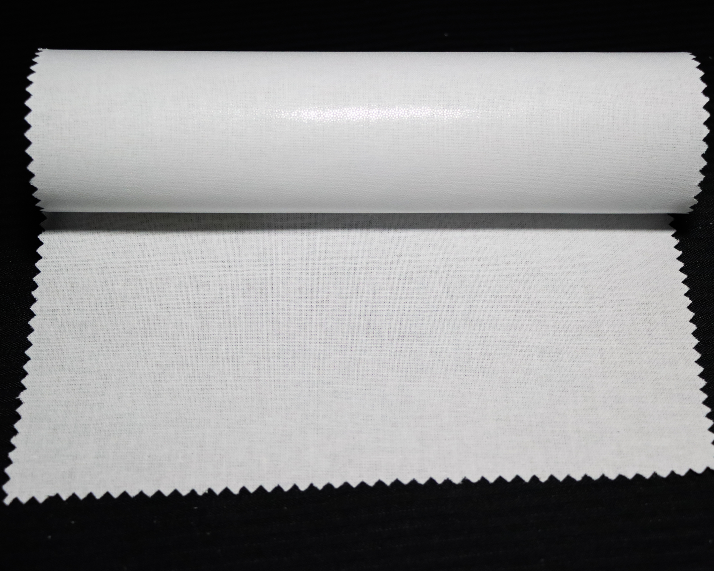 sample of white fusible interlining fabric on a black background