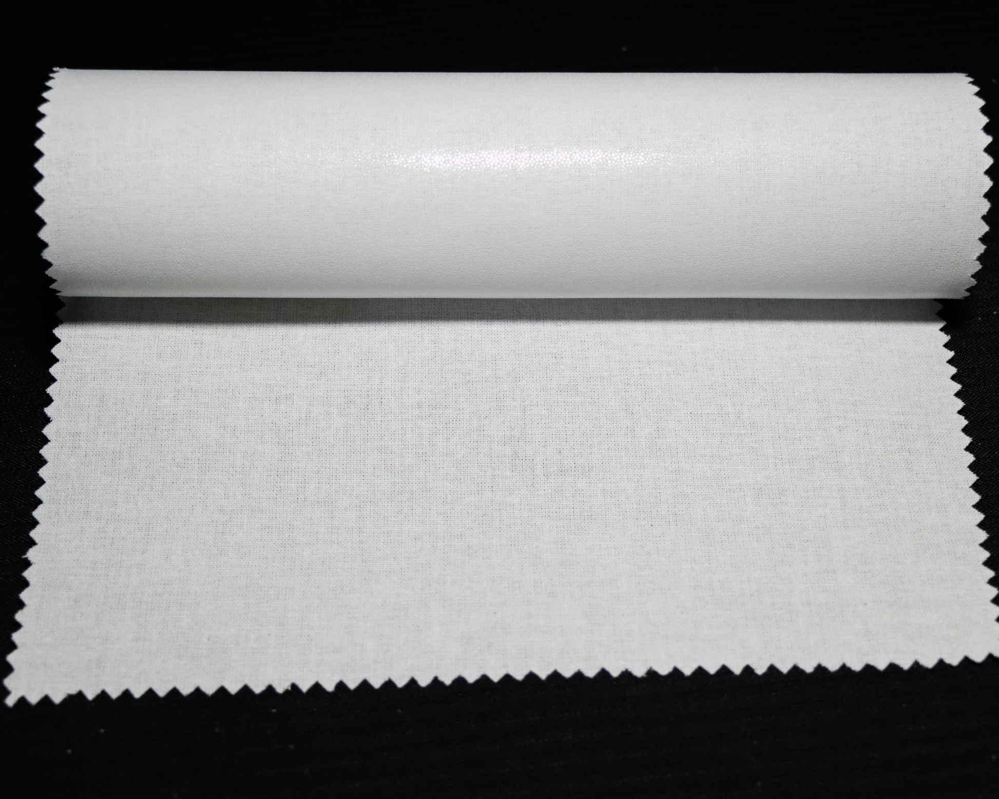 sample of white fusible interlining fabric on a black background