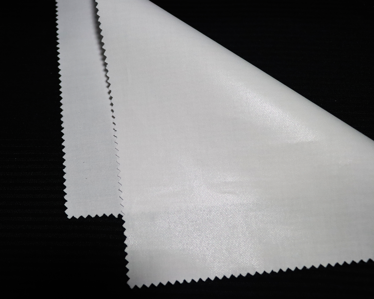 Close-up of IF84 Arabic thobe interlining fabric on a black background