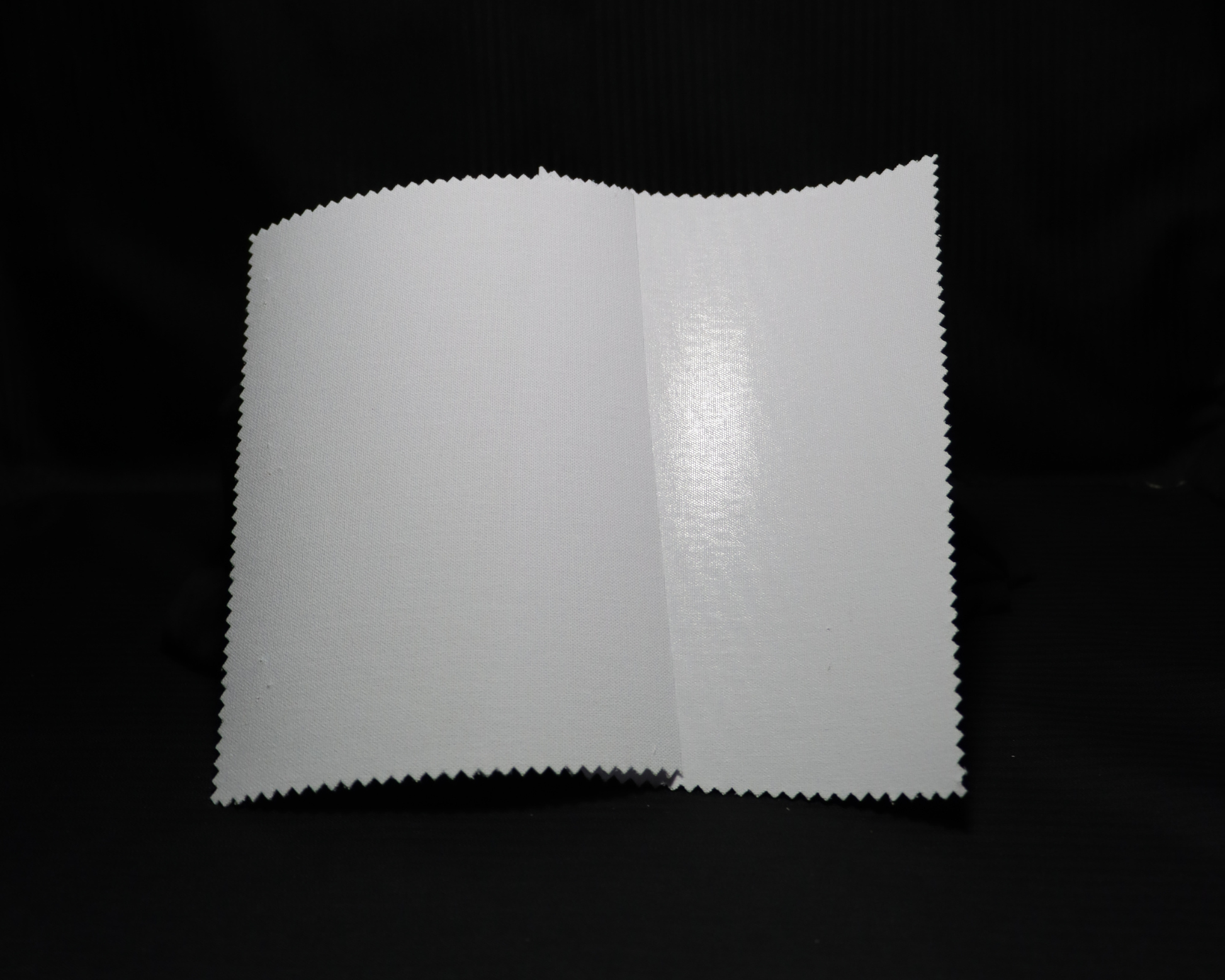 two fusible white colour interlining samples on a black background