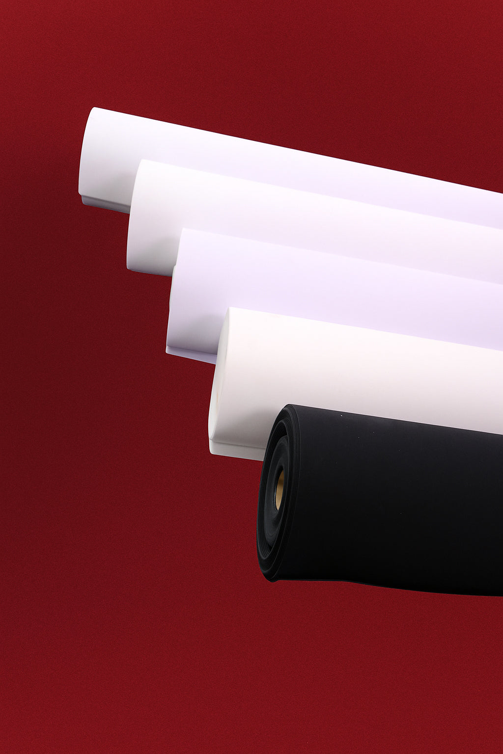 Five rolls of shirt interlining on red background